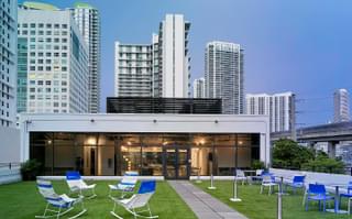 The exterior of a meeting space showing a outdoor patio area with plenty of chairs.