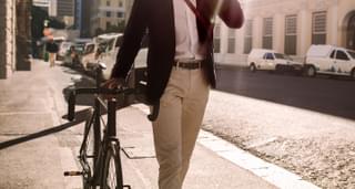 A man walking to his office with his bike.